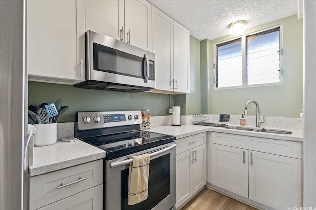 1684 Ala Moana Blvd Unit 251, Honolulu, HI 96815 - kitchen featuring stainless steel appliances, a textured ceiling, white cabinets, light wood-type flooring, and light stone countertops