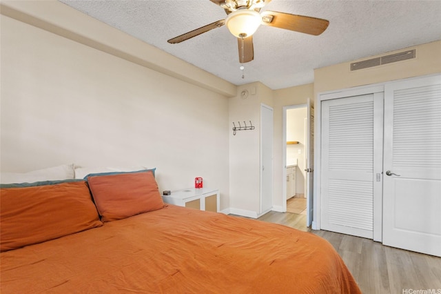 1684 Ala Moana Blvd Unit 251, Honolulu, HI 96815 - bedroom featuring a textured ceiling, wood finished floors, a closet, ceiling fan, and connected bathroom