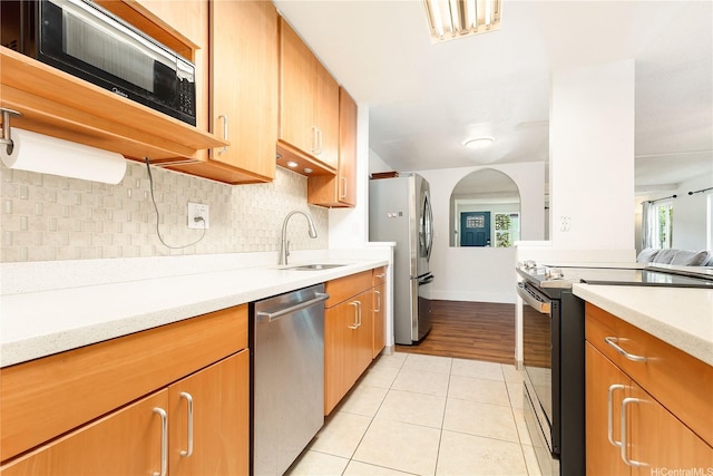 94-170 Apele Pl, Mililani, HI 96789 - kitchen featuring appliances with stainless steel finishes, light countertops, light tile patterned floors, decorative backsplash, and arched walkways