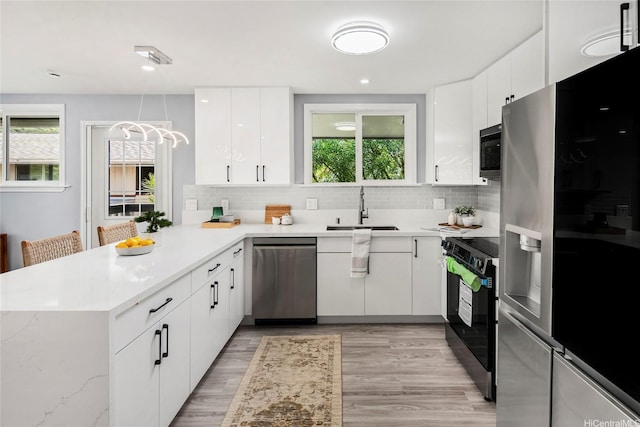 1989 9th Ave, Honolulu, HI 96816 - kitchen with appliances with stainless steel finishes, a peninsula, decorative backsplash, white cabinets, and healthy amount of natural light
