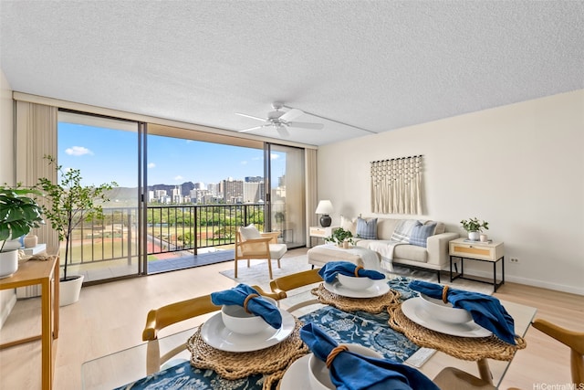 2444 Hihiwai St Unit 902, Honolulu, HI 96826 - living room featuring wood finished floors, ceiling fan, floor to ceiling windows, a textured ceiling, and a city view
