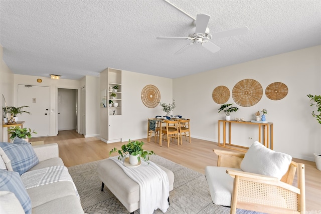2444 Hihiwai St Unit 902, Honolulu, HI 96826 - living room featuring light wood-style flooring, ceiling fan, and a textured ceiling