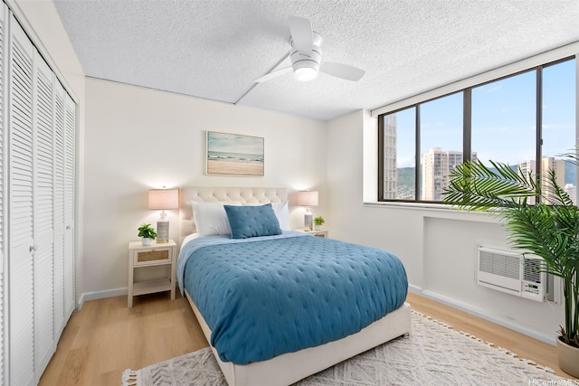 2444 Hihiwai St Unit 902, Honolulu, HI 96826 - bedroom featuring multiple windows, wood finished floors, a textured ceiling, a closet, and a ceiling fan