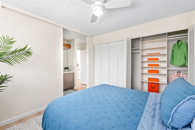 2444 Hihiwai St Unit 902, Honolulu, HI 96826 - bedroom featuring light wood-style flooring, two closets, a textured ceiling, and ceiling fan