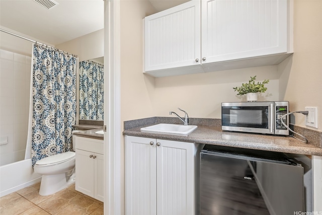 91-1030 Kai Uhu St, Ewa Beach, HI 96706 - kitchen with stainless steel microwave, white cabinets, light tile patterned floors, and dishwasher