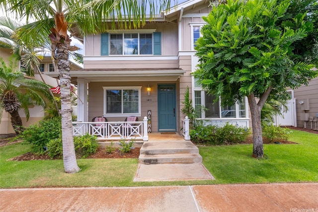 91-1030 Kai Uhu St, Ewa Beach, HI 96706 - view of front of property with a porch, a front lawn, and board and batten siding