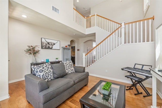 91-1030 Kai Uhu St, Ewa Beach, HI 96706 - living area featuring arched walkways, stairway, a towering ceiling, light wood-type flooring, and recessed lighting