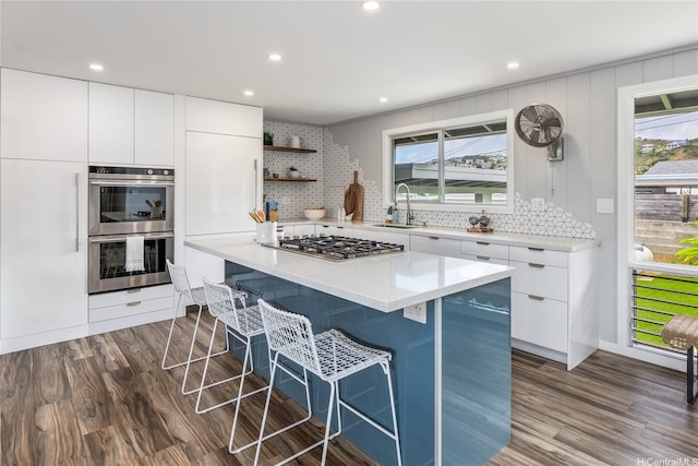 1384 Nanawale Pl, Kailua, HI 96734 - kitchen featuring appliances with stainless steel finishes, a kitchen bar, backsplash, dark wood-style floors, and recessed lighting