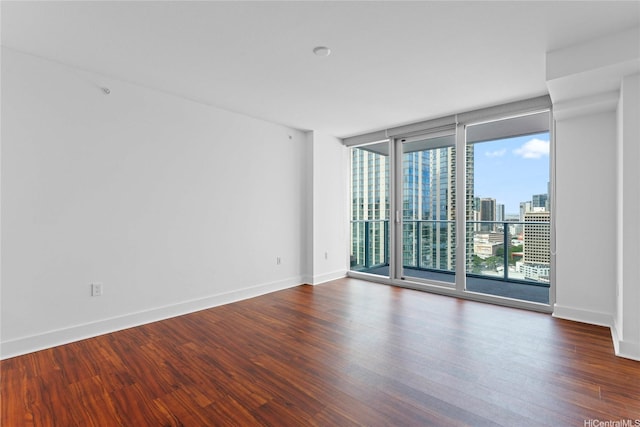 629 Keeaumoku St Unit 2408, Honolulu, HI 96814 - empty room featuring a wall of windows, dark wood-style floors, and a city view