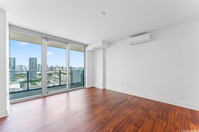 629 Keeaumoku St Unit 2408, Honolulu, HI 96814 - unfurnished room featuring a wall mounted AC, wood finished floors, a skyline view, and a wall of windows