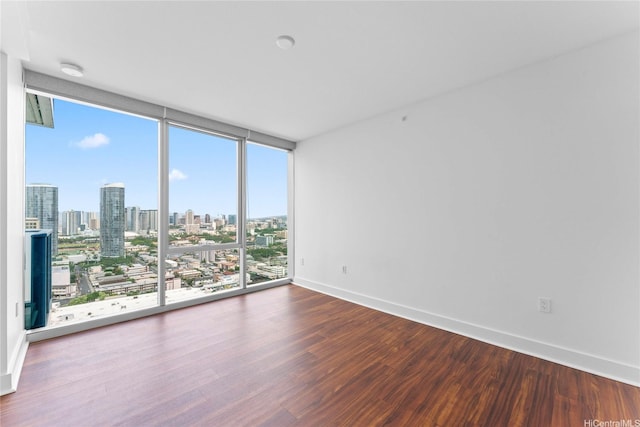 629 Keeaumoku St Unit 2408, Honolulu, HI 96814 - empty room featuring wood finished floors, a skyline view, a smoke detector, and expansive windows