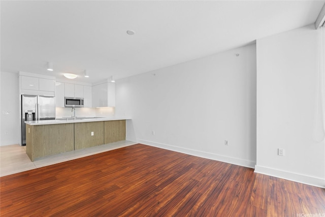 629 Keeaumoku St Unit 2408, Honolulu, HI 96814 - kitchen featuring stainless steel appliances, modern cabinets, a peninsula, light wood-style flooring, and light countertops