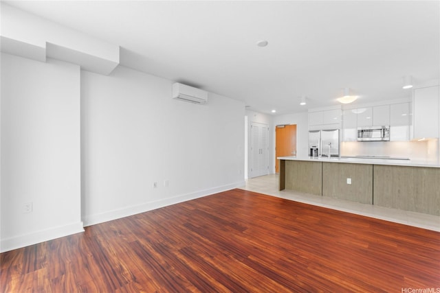 629 Keeaumoku St Unit 2408, Honolulu, HI 96814 - unfurnished living room featuring a wall mounted air conditioner, wood finished floors, and recessed lighting