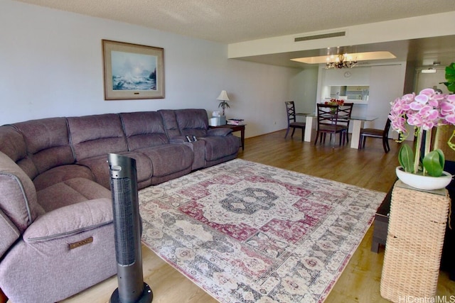 1860 Ala Moana Blvd Unit 910, Honolulu, HI 96815 - living room featuring wood finished floors, a chandelier, and a textured ceiling