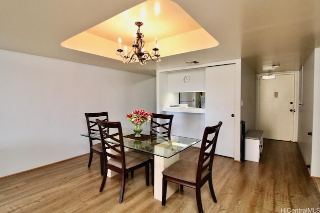 1860 Ala Moana Blvd Unit 910, Honolulu, HI 96815 - dining space with a chandelier, wood finished floors, and a tray ceiling