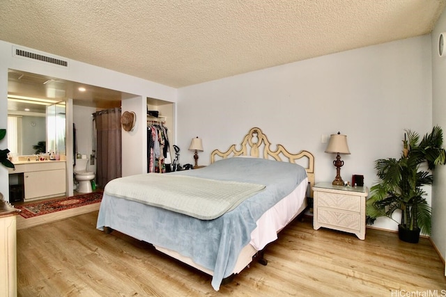 1860 Ala Moana Blvd Unit 910, Honolulu, HI 96815 - bedroom with light wood finished floors, ensuite bathroom, a textured ceiling, a spacious closet, and a closet
