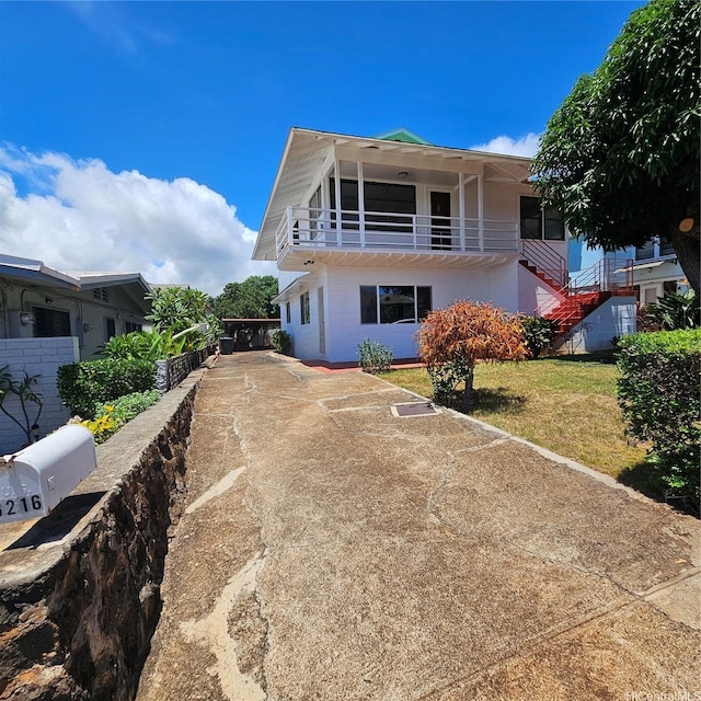3216 Kaimuki Ave, Honolulu, HI 96816 - view of front of home featuring driveway, stairs, a balcony, and a front lawn