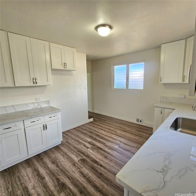 3216 Kaimuki Ave, Honolulu, HI 96816 - kitchen with light stone counters, dark wood-style floors, white cabinets, and a textured ceiling