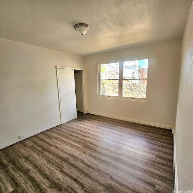 3216 Kaimuki Ave, Honolulu, HI 96816 - unfurnished bedroom with dark wood-style floors, a closet, and a textured ceiling