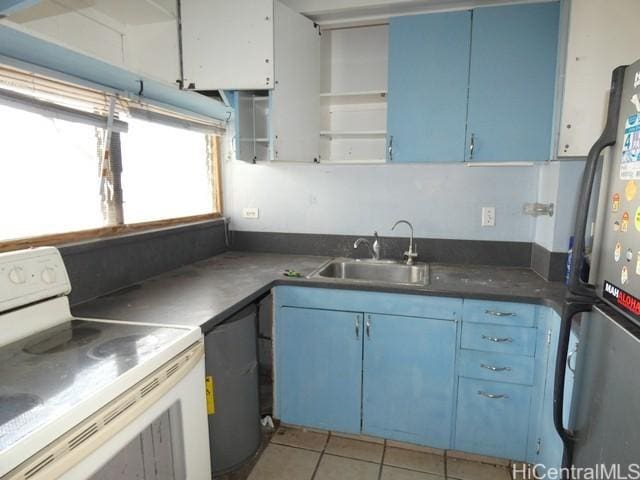 2421 Ala Wai Blvd Unit 1701, Honolulu, HI 96815 - kitchen with white electric stove, freestanding refrigerator, blue cabinets, open shelves, and light tile patterned flooring