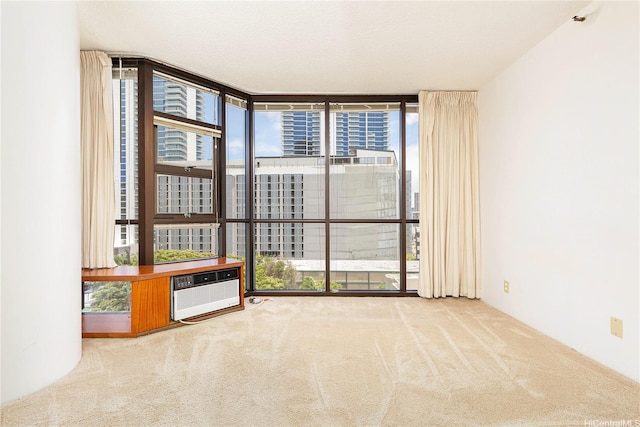 930 Kaheka St Unit 802, Honolulu, HI 96814 - spare room with a wall of windows, carpet flooring, and a wall mounted air conditioner