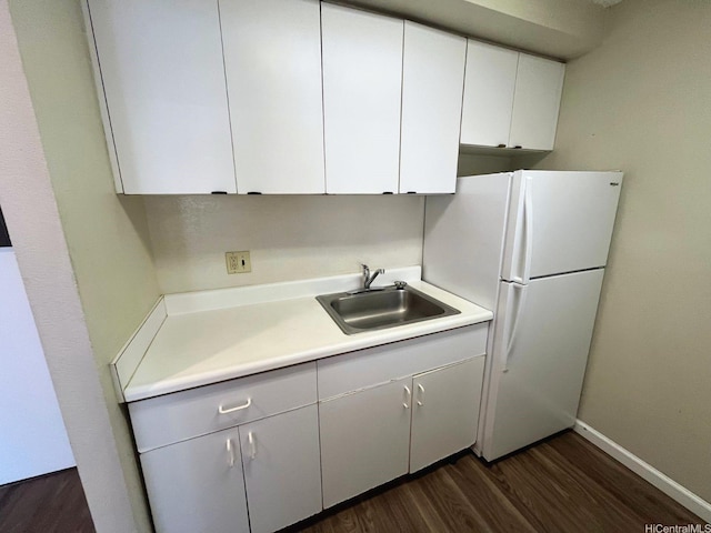 1617 Kapiolani Blvd Unit 1003, Honolulu, HI 96814 - kitchen with dark wood finished floors, freestanding refrigerator, light countertops, and white cabinetry