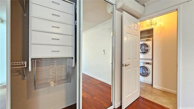 1848 Kahakai Dr Unit 1502, Honolulu, HI 96814 - laundry room featuring stacked washing machine and dryer, a wall unit AC, crown molding, a chandelier, and dark tile patterned flooring