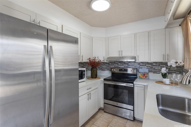 3225 Ala Ilima St Unit 2, Honolulu, HI 96818 - kitchen with stainless steel appliances, light countertops, a textured ceiling, under cabinet range hood, and white cabinets
