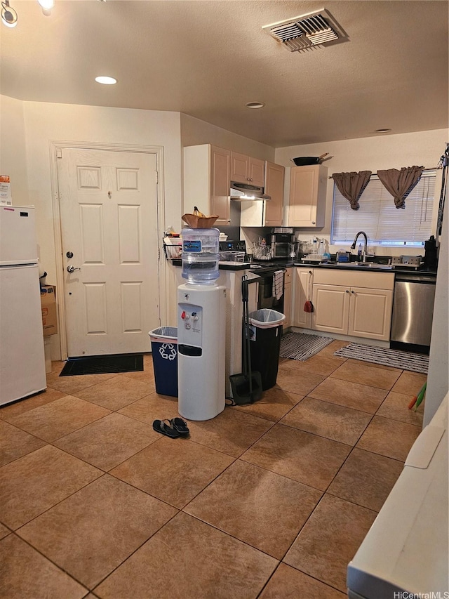 87-1976 Pakeke St Unit B, Waianae, HI 96792 - kitchen with freestanding refrigerator, stainless steel dishwasher, dark countertops, tile patterned floors, and under cabinet range hood