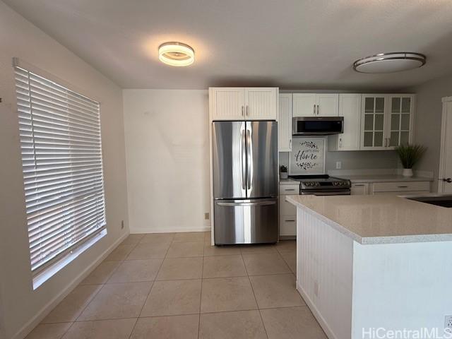 94-586 Lumiauau St Unit N104, Waipahu, HI 96797 - kitchen featuring appliances with stainless steel finishes, light countertops, white cabinetry, and light tile patterned floors