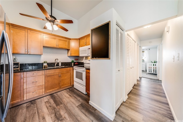 95-150 Kuahelani Ave Unit 255, Mililani, HI 96789 - kitchen with white appliances, dark wood-type flooring, ceiling fan, vaulted ceiling, and dark stone countertops