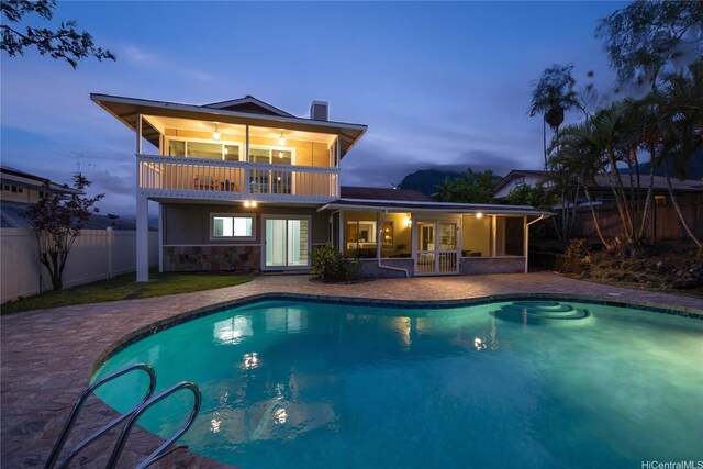 46-259 Kalali St, Kaneohe, HI 96744 - rear view of property featuring a balcony, a fenced backyard, a patio, stone siding, and french doors