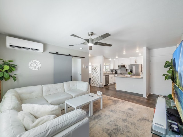 91-1348 Kakiwi St, Ewa Beach, HI 96706 - living area with an AC wall unit, a barn door, dark wood finished floors, and a ceiling fan