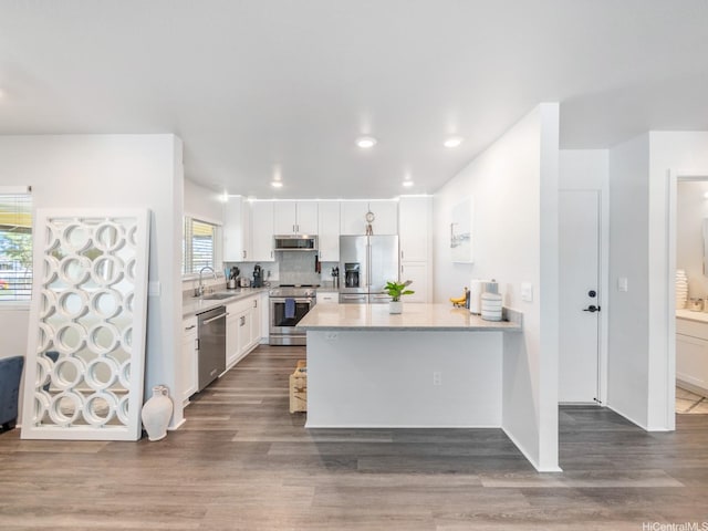 91-1348 Kakiwi St, Ewa Beach, HI 96706 - kitchen with stainless steel appliances, light countertops, a peninsula, white cabinetry, and wood finished floors