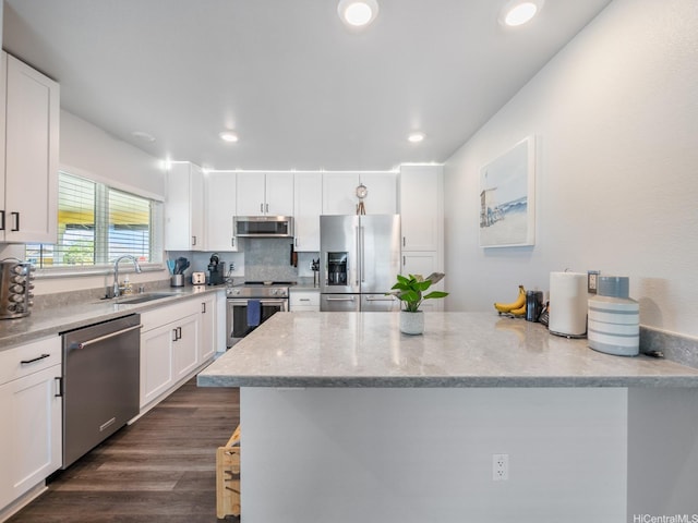 91-1348 Kakiwi St, Ewa Beach, HI 96706 - kitchen with appliances with stainless steel finishes, white cabinetry, light stone countertops, recessed lighting, and dark wood-type flooring