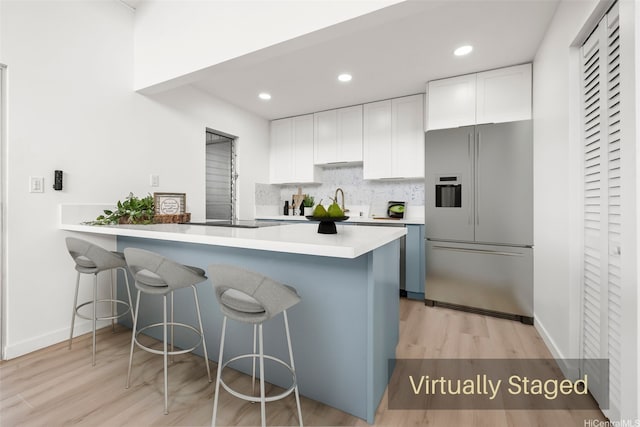 94-431 Keaoopua St Unit 104, Mililani, HI 96789 - kitchen with high end refrigerator, light wood-type flooring, a breakfast bar area, white cabinets, and recessed lighting
