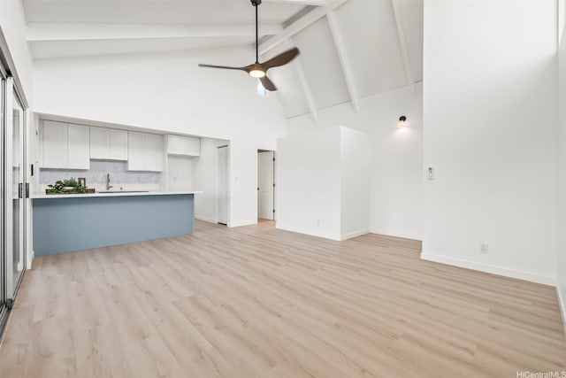 94-431 Keaoopua St Unit 104, Mililani, HI 96789 - unfurnished living room featuring high vaulted ceiling, beamed ceiling, light wood-style floors, and ceiling fan