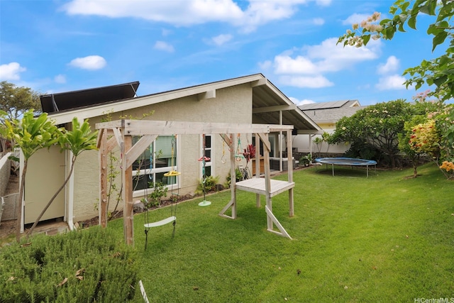 7780 Waikapu Loop, Honolulu, HI 96825 - rear view of property featuring a trampoline, stucco siding, and a yard