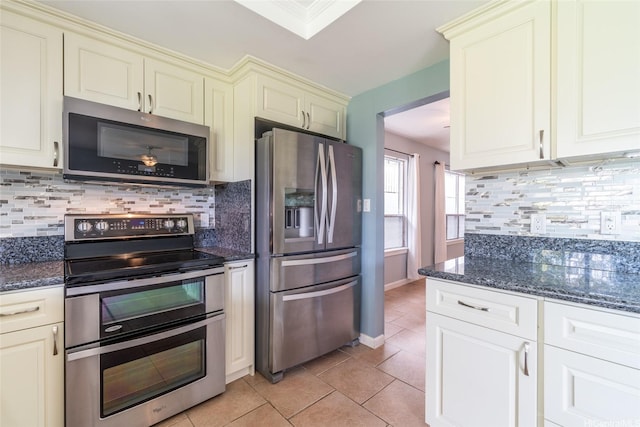 1335 Onioni St, Kailua, HI 96734 - kitchen featuring appliances with stainless steel finishes, cream cabinetry, tasteful backsplash, dark stone countertops, and light tile patterned flooring