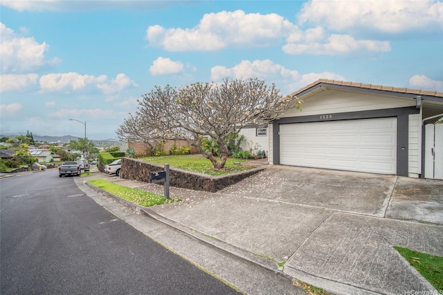 1335 Onioni St, Kailua, HI 96734 - ranch-style home featuring an attached garage, concrete driveway, and a mountain view