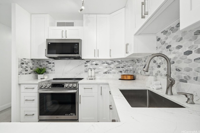 2575 Kuhio Ave Unit 1702, Honolulu, HI 96815 - kitchen with appliances with stainless steel finishes, light stone counters, white cabinets, and backsplash