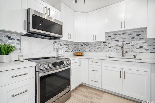 2575 Kuhio Ave Unit 1702, Honolulu, HI 96815 - kitchen featuring stainless steel appliances, white cabinetry, backsplash, light wood-style flooring, and light stone countertops