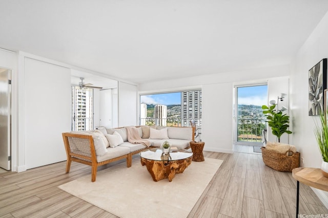 2575 Kuhio Ave Unit 1702, Honolulu, HI 96815 - living area featuring light wood finished floors, healthy amount of natural light, and a ceiling fan