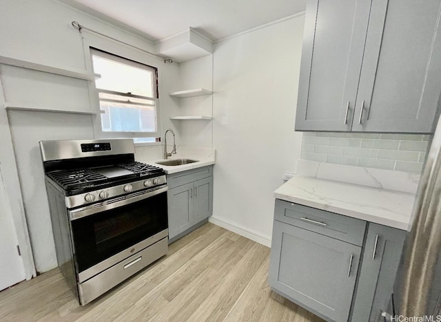 631 Hausten St Unit 2, Honolulu, HI 96826 - kitchen featuring open shelves, stainless steel range with gas cooktop, gray cabinets, light wood finished floors, and crown molding