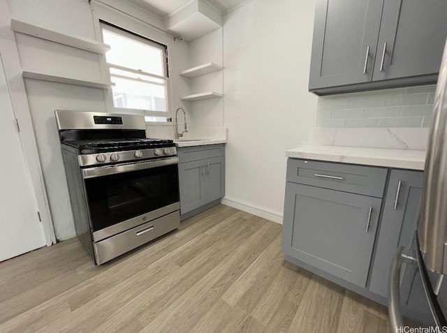 631 Hausten St Unit 2, Honolulu, HI 96826 - kitchen featuring gray cabinetry, gas range, open shelves, and light wood finished floors