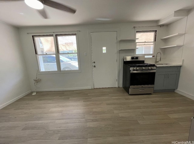 631 Hausten St Unit 2, Honolulu, HI 96826 - kitchen featuring stainless steel range with gas cooktop, open shelves, gray cabinetry, a ceiling fan, and light wood-style floors