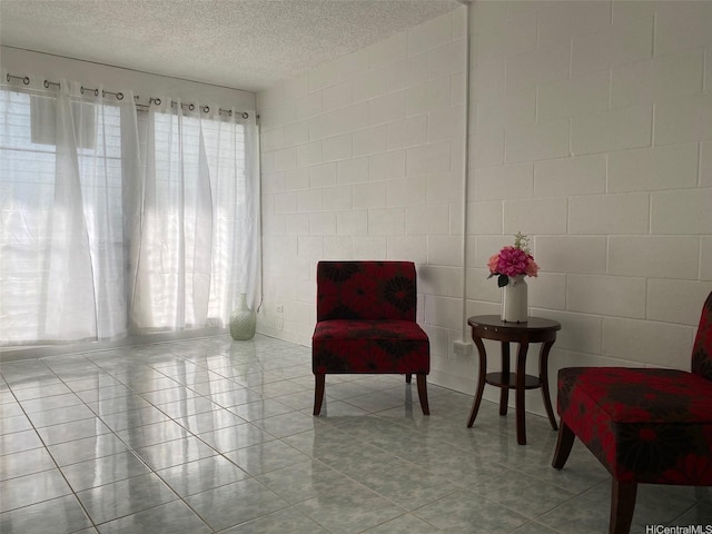 1118 Pua Ln Unit 113, Honolulu, HI 96817 - sitting room featuring a textured ceiling, light tile patterned floors, and tile walls