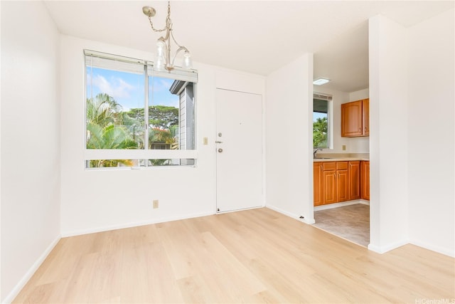 95-670 Hanile St Unit A202, Mililani, HI 96789 - unfurnished dining area featuring light wood-style flooring, healthy amount of natural light, and a chandelier
