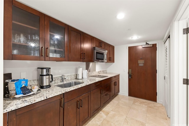 223 Saratoga Rd Unit 1916, Honolulu, HI 96815 - kitchen with stainless steel microwave, glass insert cabinets, light stone countertops, black electric cooktop, and light tile patterned flooring