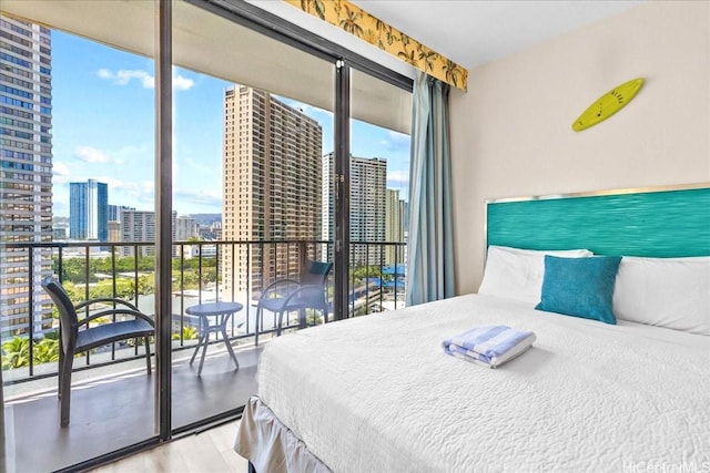 1850 Ala Moana Blvd Unit 1107, Honolulu, HI 96815 - bedroom featuring a view of skyline, access to outside, multiple windows, and wood finished floors